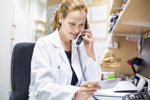Pharmacist using landline phone in store
